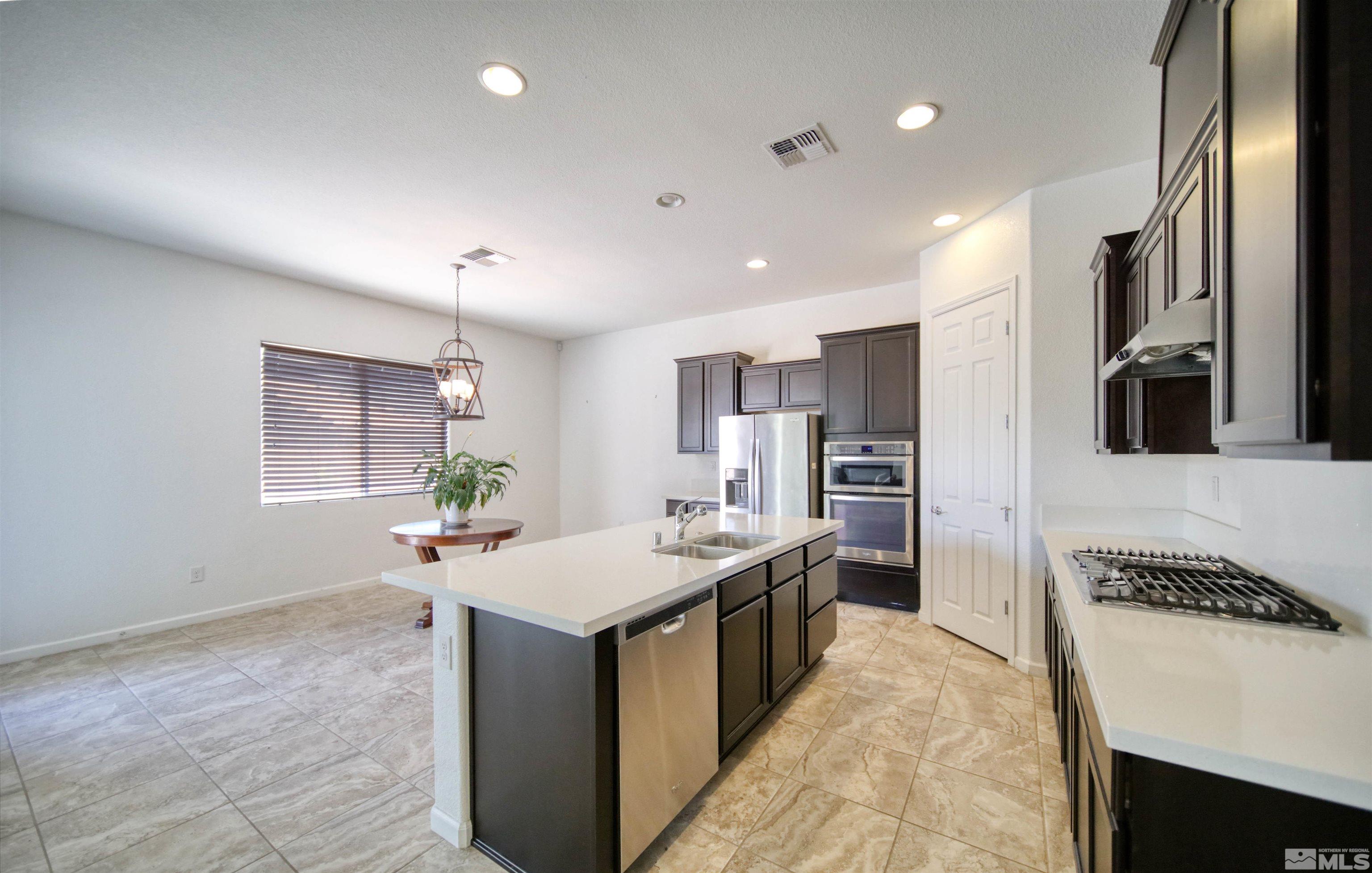 10080 Ellis Park Lane Reno, NV 89521 - Photo 4 of 26 a kitchen with stainless steel appliances granite countertop a sink stove and refrigerator