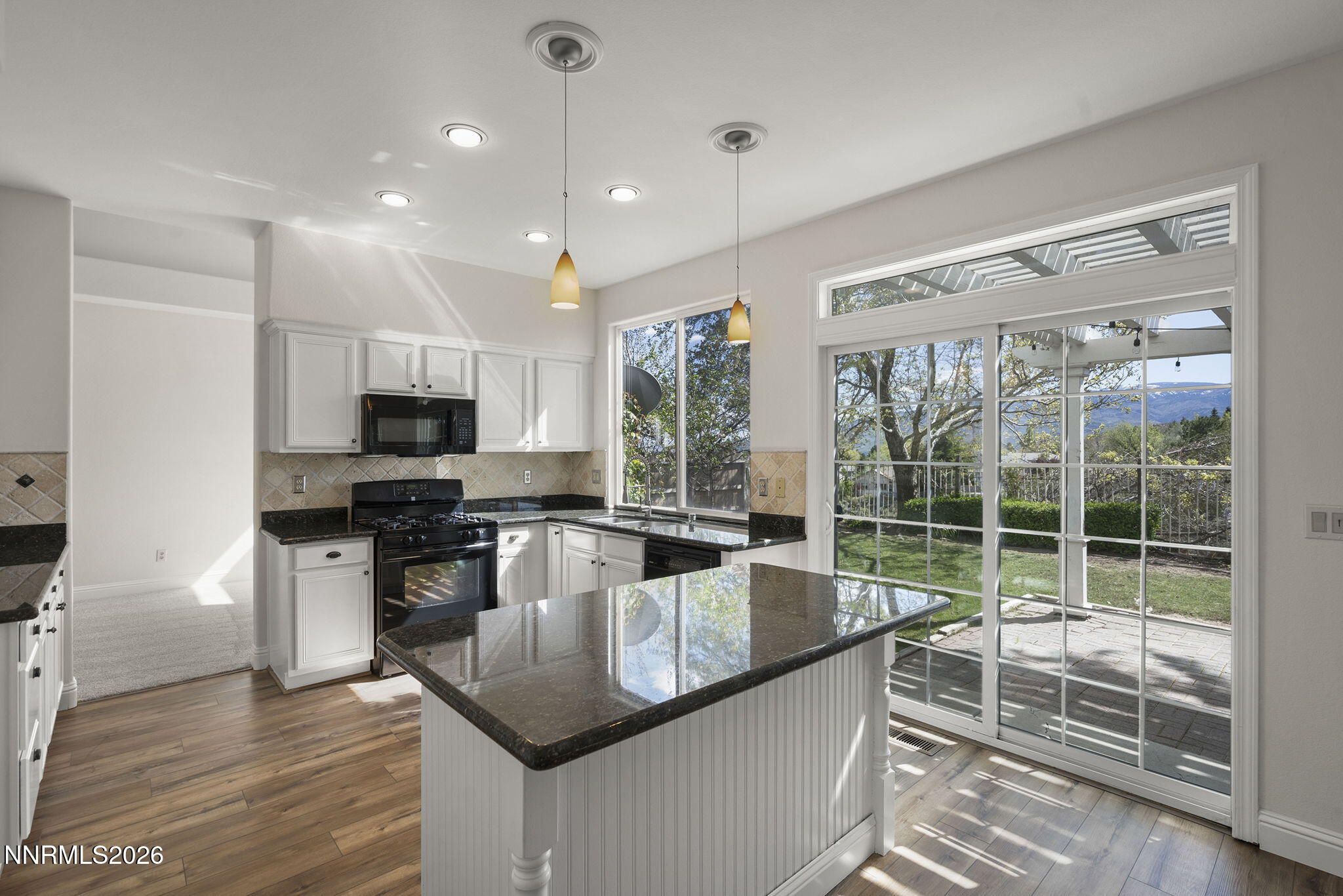 5490 Twin Creeks Drive Reno, NV 89523 - Photo 8 of 27 a kitchen with stainless steel appliances granite countertop a sink stove and wooden floor