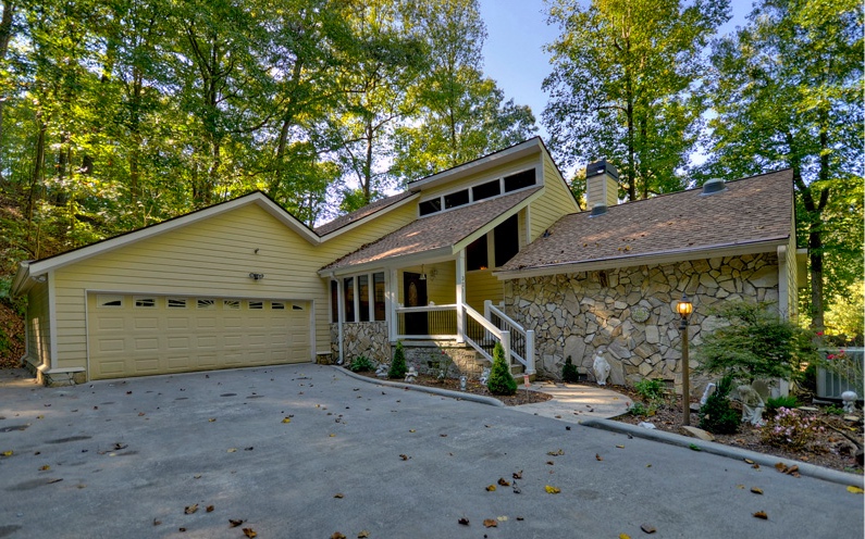 a view of a house with a yard and large tree