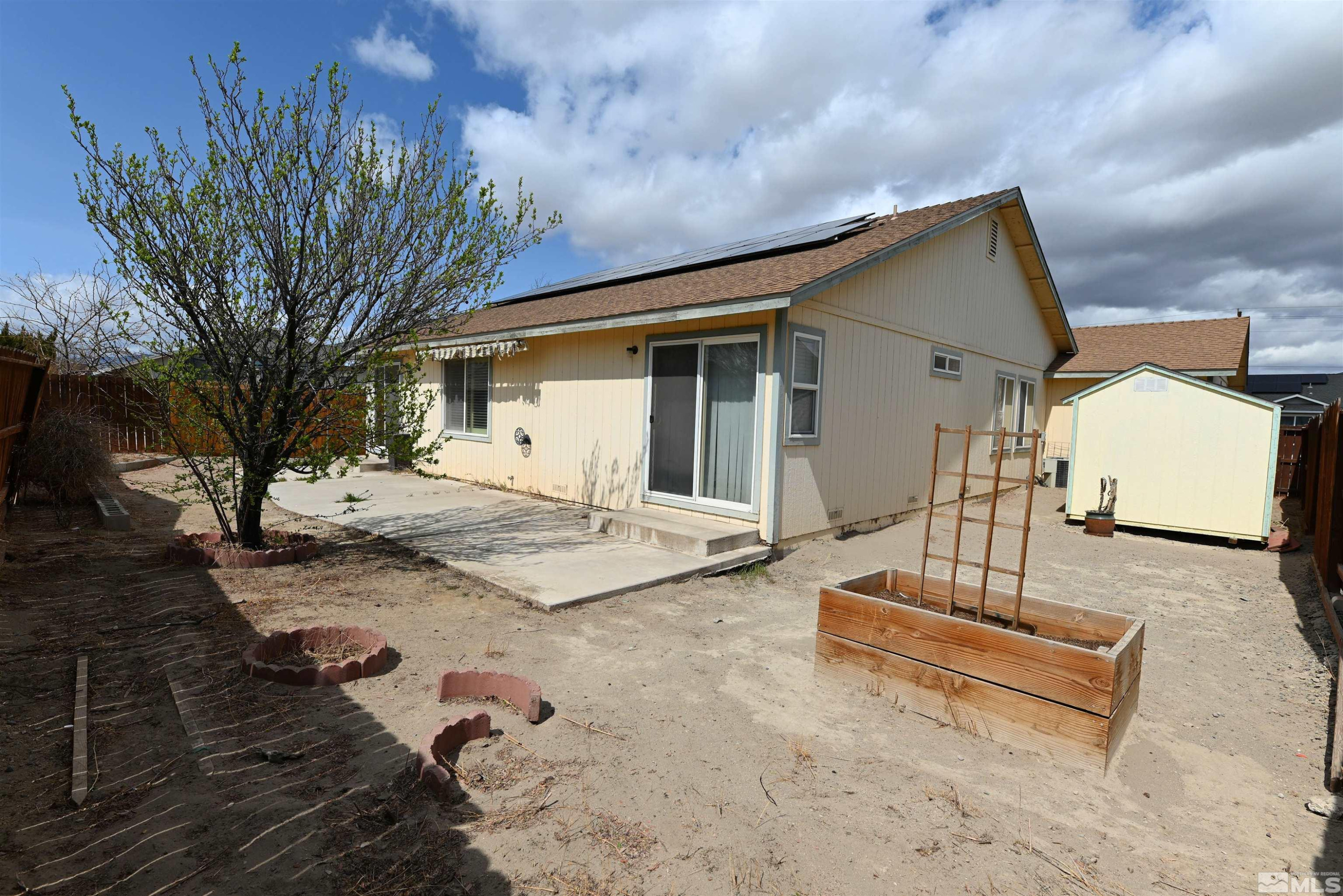 2129 Fort Bridger Road Fernley, NV 89408 - Photo 13 of 21 a view of a white house with a large tree and wooden fence