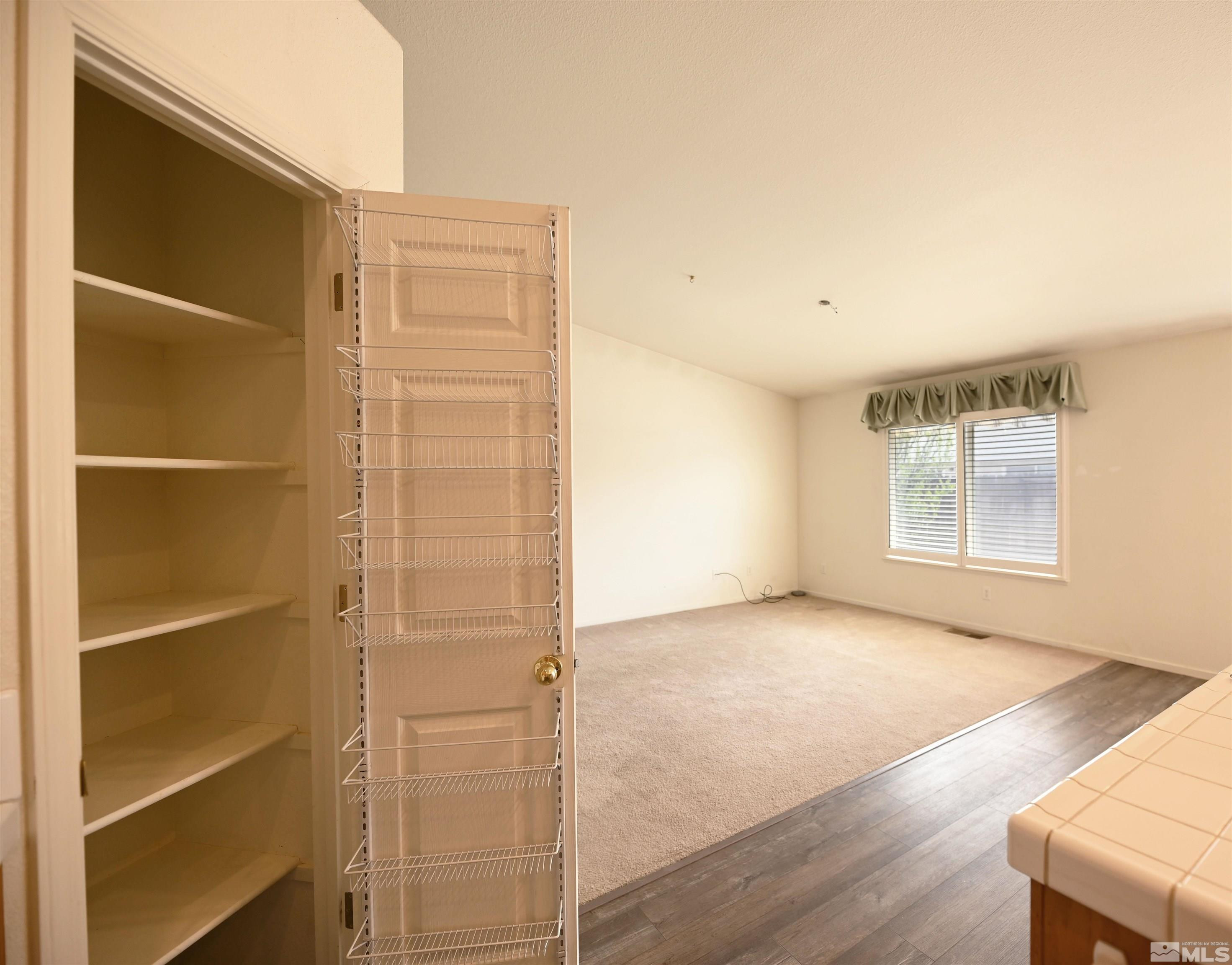 2129 Fort Bridger Road Fernley, NV 89408 - Photo 19 of 21 a view of an empty room with wooden floor and a window