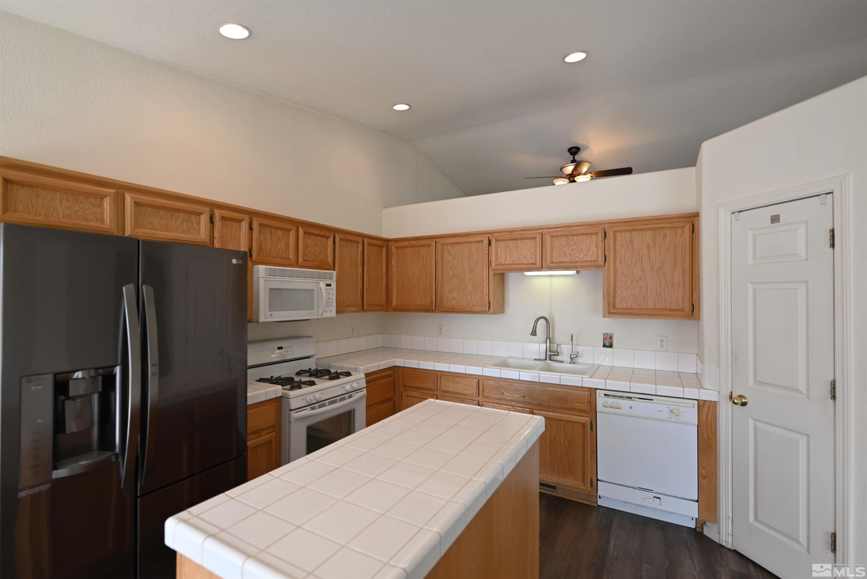 2129 Fort Bridger Road Fernley, NV 89408 - Photo 6 of 21 a kitchen with a sink a refrigerator a stove and cabinets