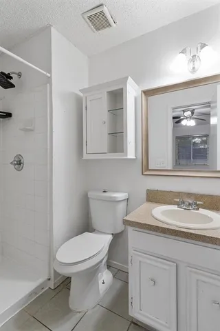 a bathroom with a granite countertop toilet sink and mirror