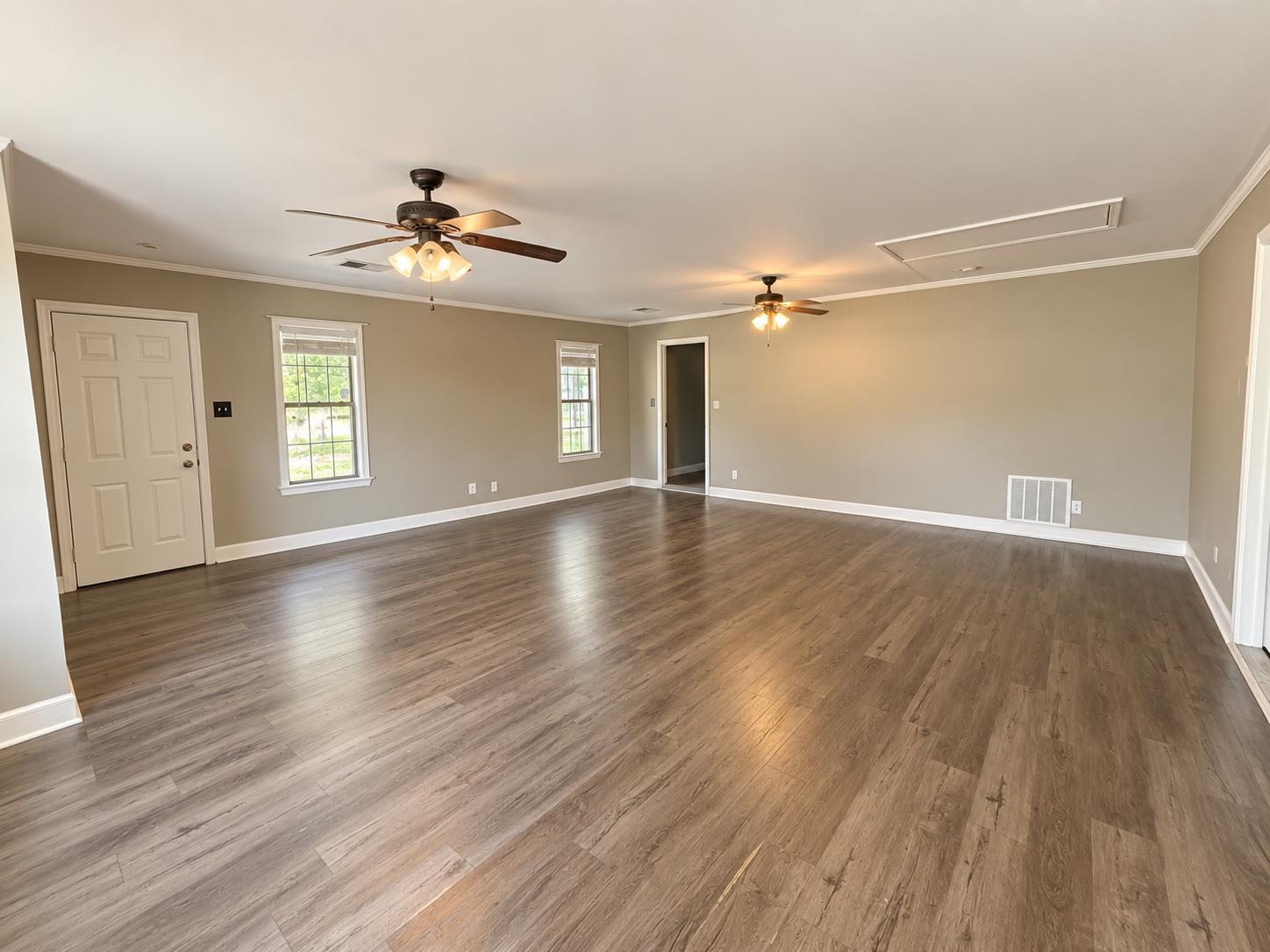 3771 West Union Road Millington, TN 38053 - Photo 10 of 16 Spacious room featuring wood-finish flooring, neutral paint palette, multiple windows, and two ceiling fans with integrated lighting