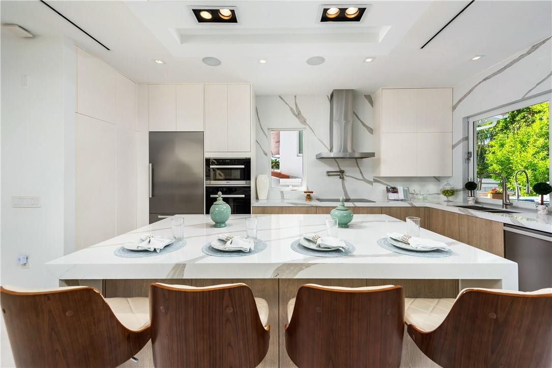 4610 Alton Road Miami Beach, FL 33140 - Photo 11 of 60 a kitchen with stainless steel appliances granite countertop a sink and white cabinets