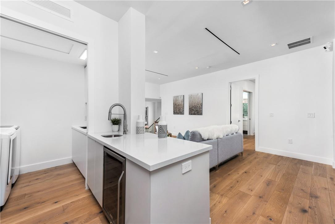 4610 Alton Road Miami Beach, FL 33140 - Photo 42 of 60 a large white kitchen with a sink and dishwasher with wooden floor