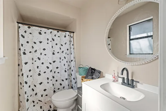 a bathroom with a sink toilet and a mirror