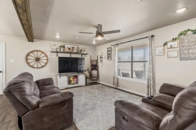 a living room with furniture a flat screen tv and a window