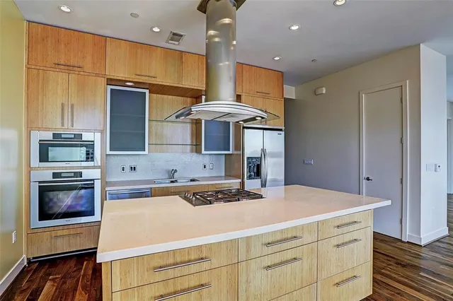 a kitchen that has a lot of cabinets and wooden floor