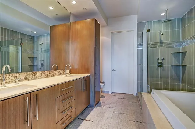 a bathroom with a tub a sink and glass door shower