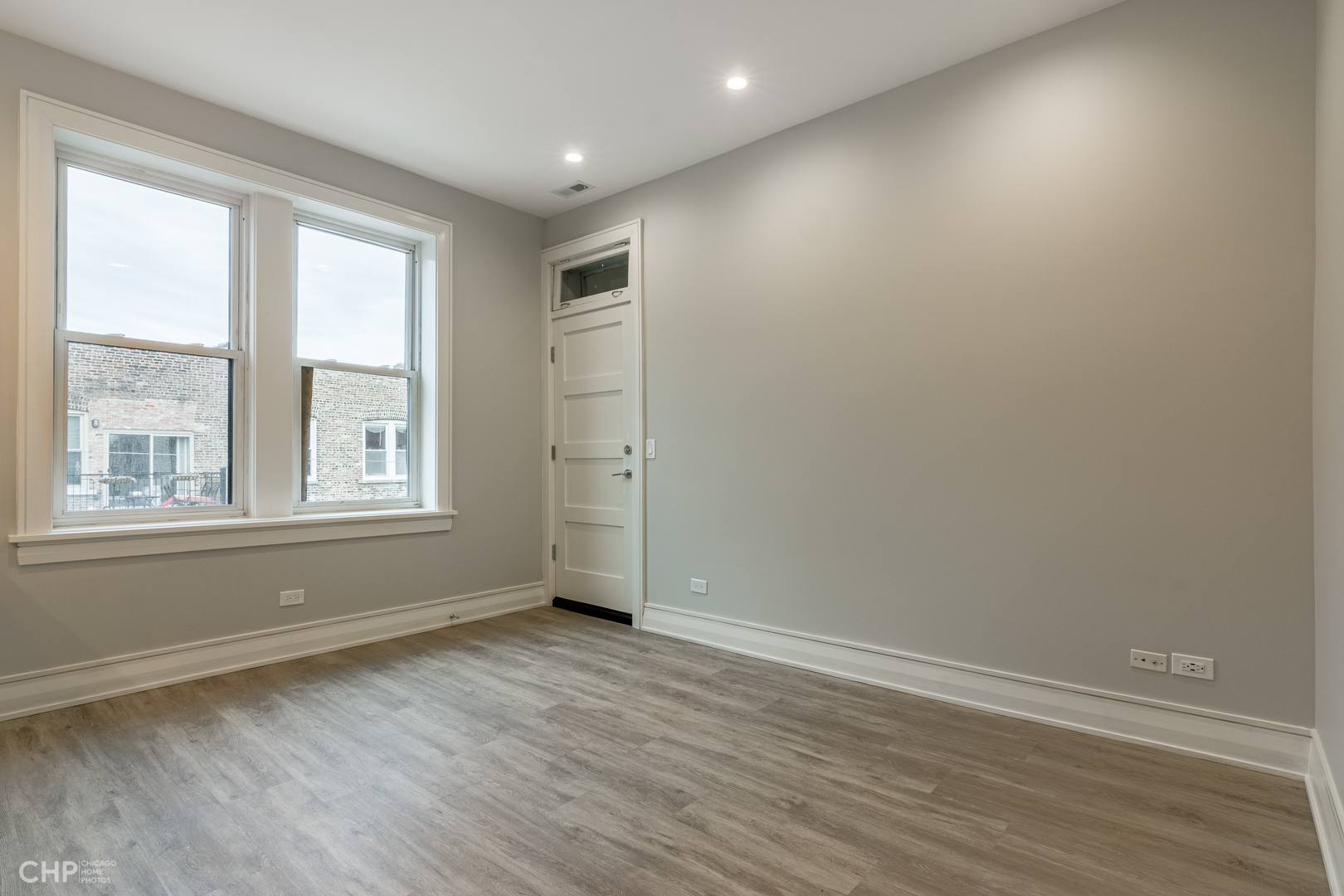 2318 West Thomas Street, Unit 3R Chicago, IL 60622 - Photo 2 of 12 an empty room with wooden floor and windows