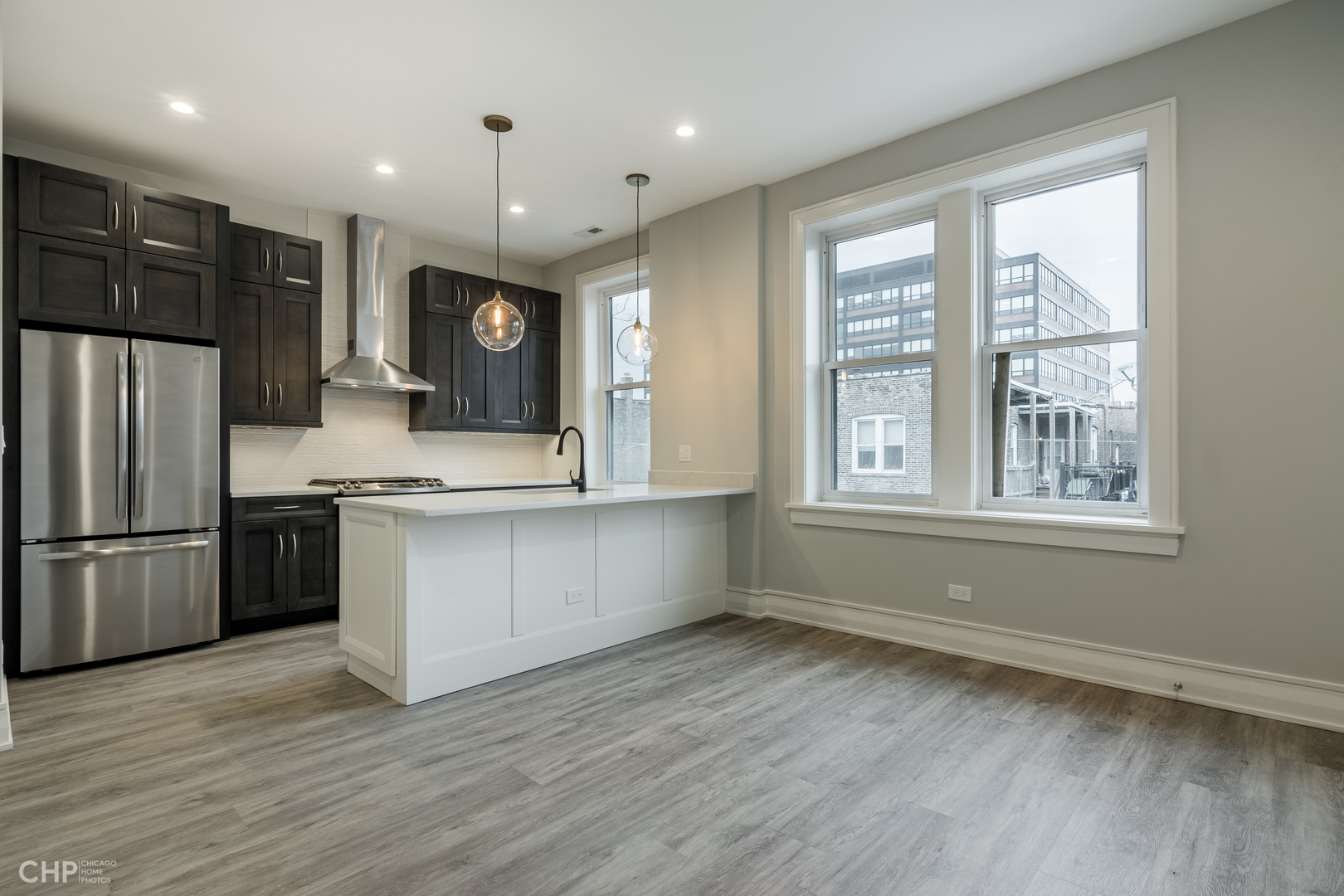 2318 West Thomas Street, Unit 3R Chicago, IL 60622 - Photo 3 of 12 a large kitchen with stainless steel appliances granite countertop a refrigerator a sink dishwasher a oven and a large countertops with wooden floor