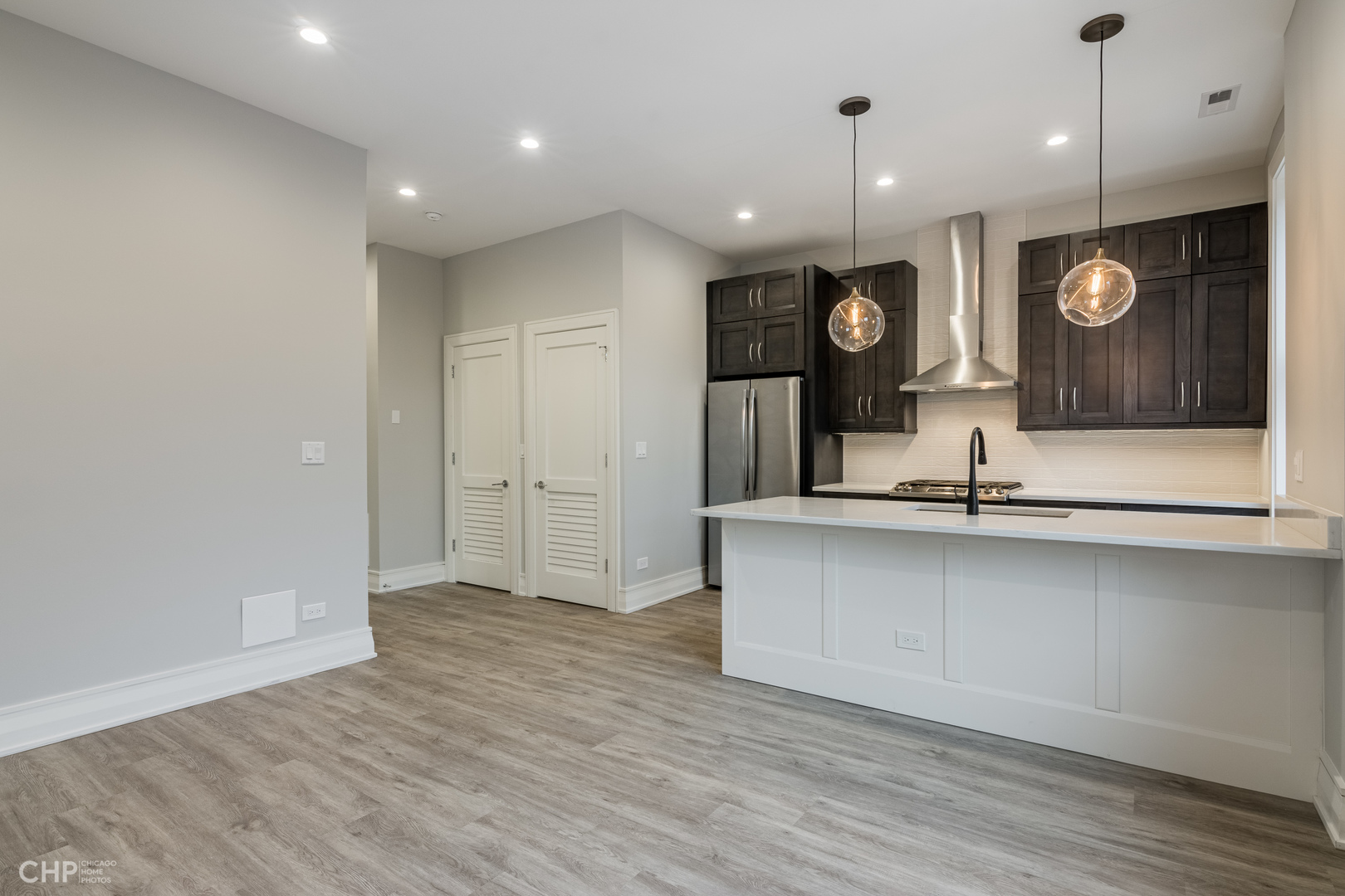 2318 West Thomas Street, Unit 3R Chicago, IL 60622 - Photo 4 of 12 an open kitchen with a sink and dishwasher with wooden floor