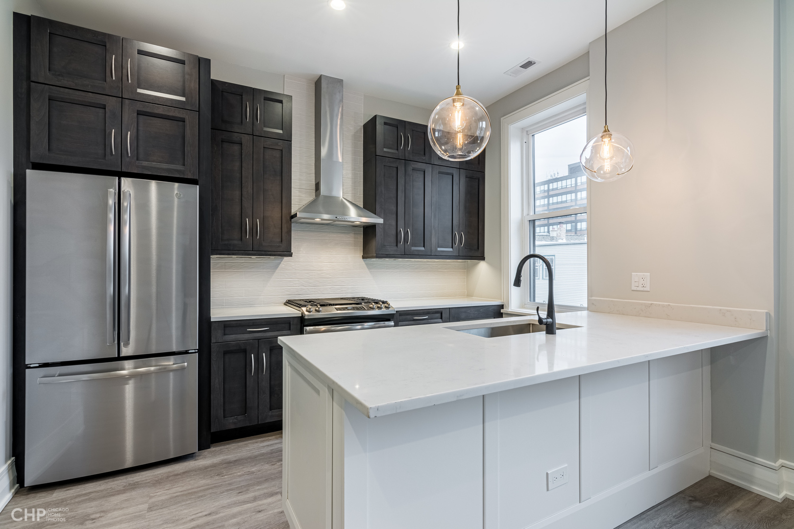 2318 West Thomas Street, Unit 3R Chicago, IL 60622 - Photo 5 of 12 a kitchen with stainless steel appliances a refrigerator a sink and cabinets