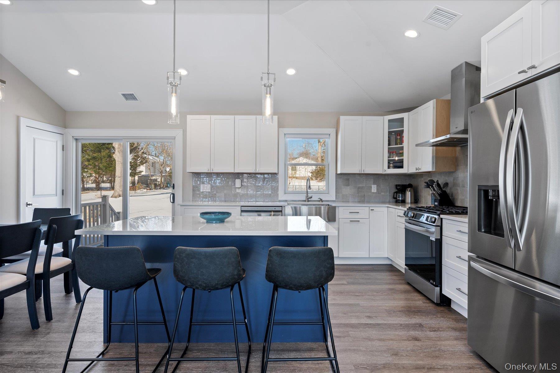 1150 Ruth Road Mattituck, NY 11952 - Photo 7 of 19 a kitchen with stainless steel appliances granite countertop a sink a stove a refrigerator cabinets and chairs