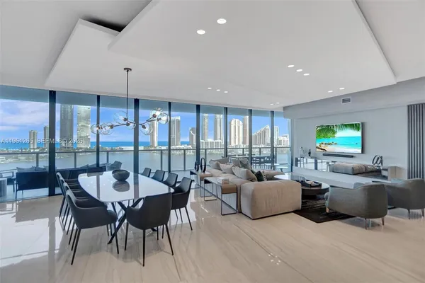 a living room with furniture a chandelier and a floor to ceiling window