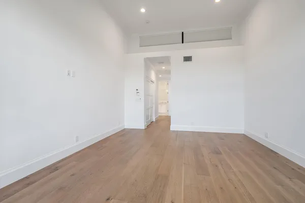 a view of an empty room with wooden floor
