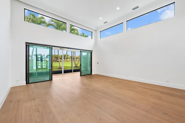 a view of an empty room with wooden floor and a sliding door