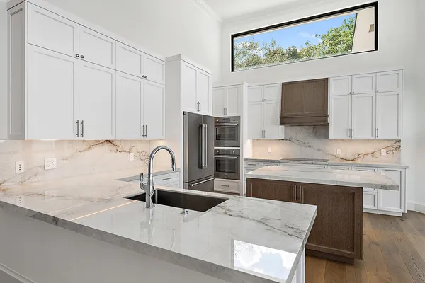 a kitchen with granite countertop a sink cabinets and stainless steel appliances