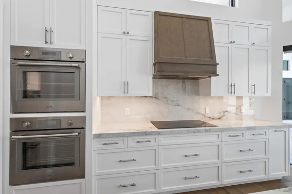 a kitchen with granite countertop white cabinets and stainless steel appliances