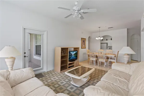 a living room with furniture a chandelier and a flat screen tv