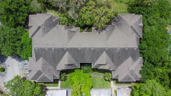 an aerial view of a house with plants and large trees