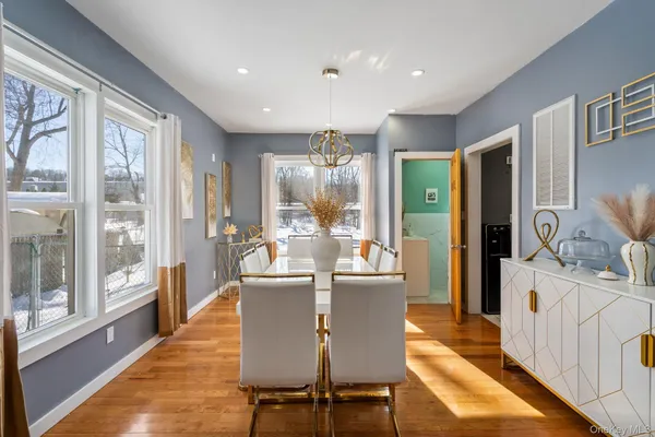 a dining room with furniture a chandelier and wooden floor