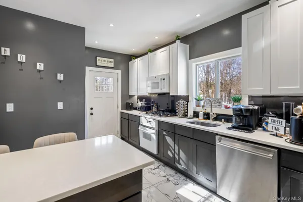 a kitchen with a sink a stove a refrigerator cabinets and a counter top space