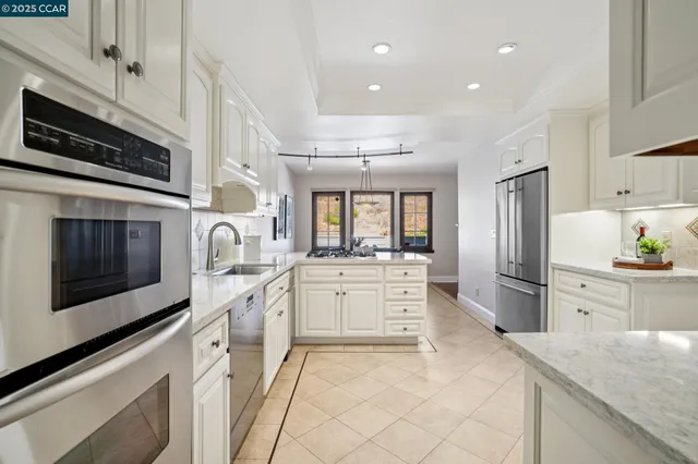 a kitchen with granite countertop a refrigerator and a sink