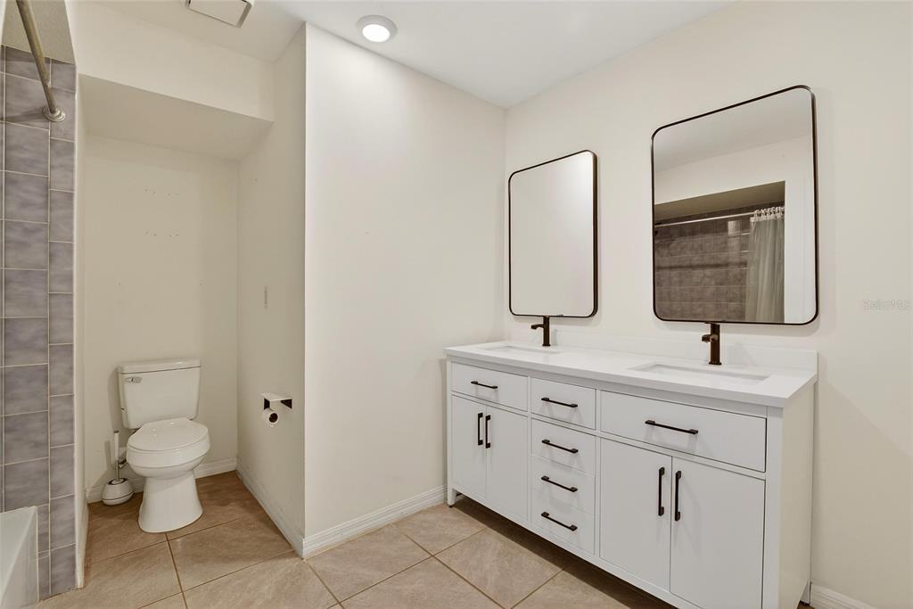 15047 Woodbury Road Brooksville, FL 34604 - Photo 26 of 98 a bathroom with a toilet a sink and mirror