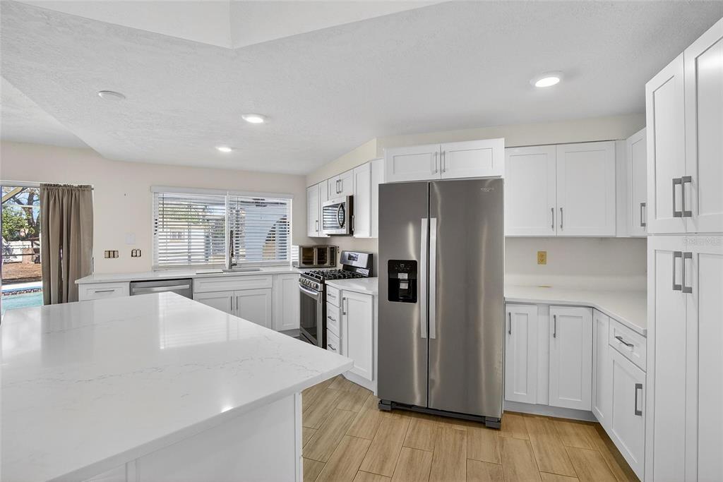 15047 Woodbury Road Brooksville, FL 34604 - Photo 42 of 98 a kitchen with white cabinets and stainless steel appliances
