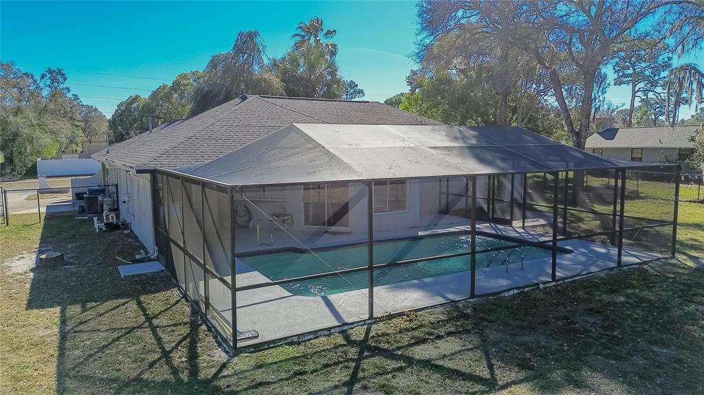 15047 Woodbury Road Brooksville, FL 34604 - Photo 97 of 98 a view of a patio with table and chairs under an umbrella with wooden fence