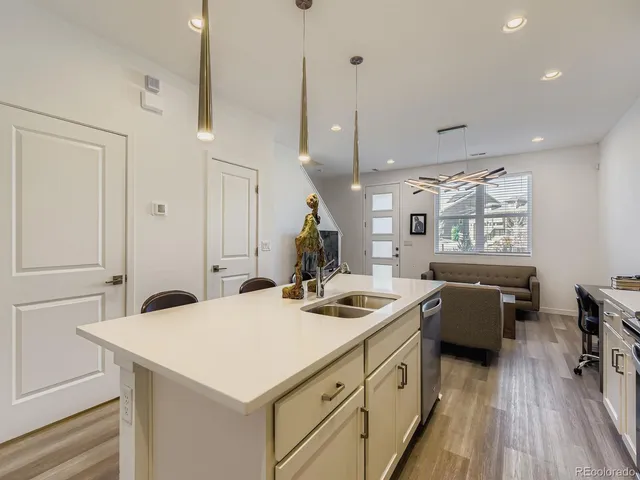 a kitchen that has a cabinets a sink and a stove with wooden floor