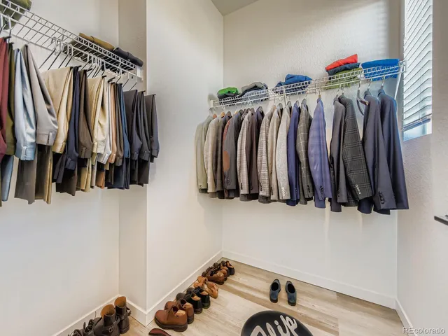 a view of walk in closet with clothes and shoes