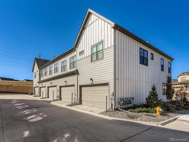 a front view of a house with yard and parking