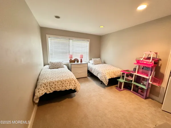 a room with a bed table gym equipment and a window