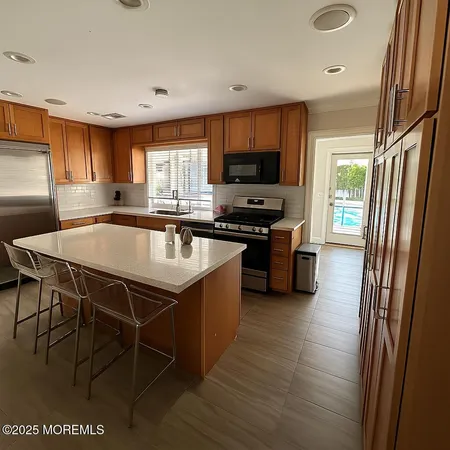 a kitchen with stainless steel appliances granite countertop a sink stove and refrigerator