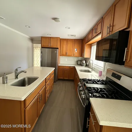 a kitchen with stainless steel appliances a sink stove and refrigerator