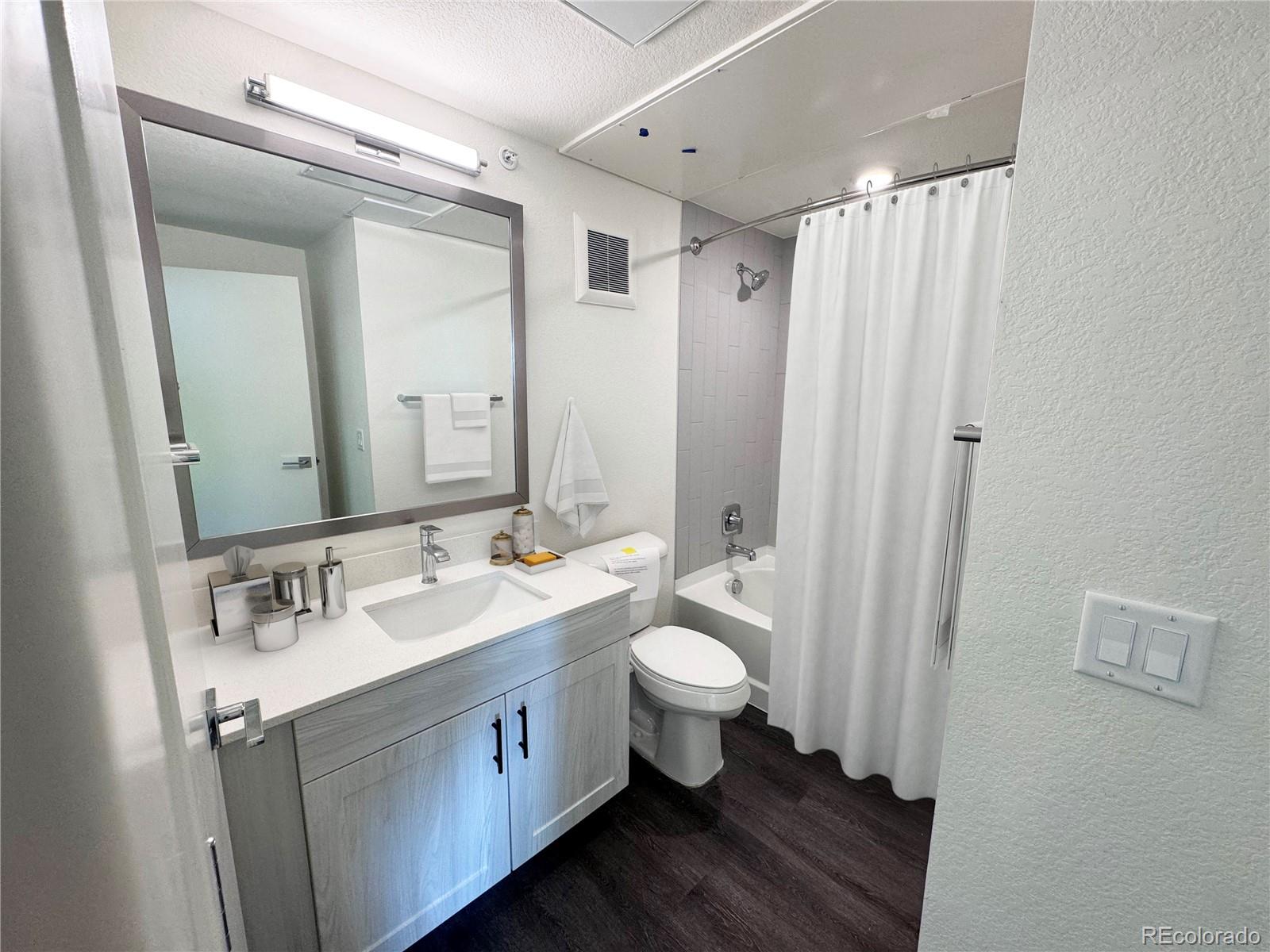 4900 West 29th Avenue, Unit 310 Denver, CO 80212 - Photo 6 of 13 a bathroom with a double vanity sink toilet and mirror