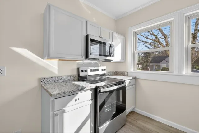 a kitchen with stainless steel appliances granite countertop a stove a sink and a microwave