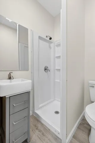a bathroom with a shower a sink and toilet