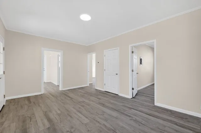 a view of an empty room with wooden floor