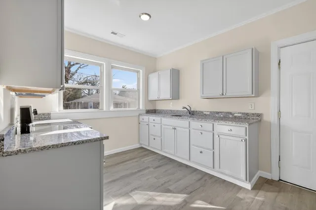 a kitchen with granite countertop cabinets stainless steel appliances a sink and a window