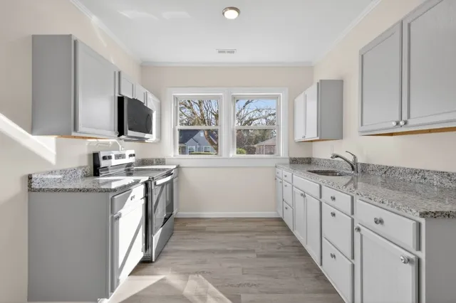 a kitchen with granite countertop a sink and a stove top oven