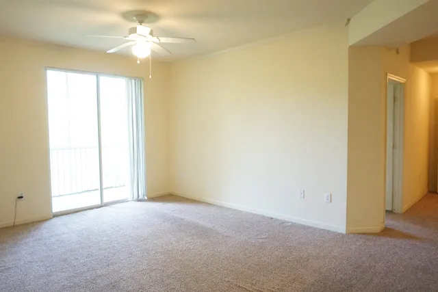 an empty room with a window and a ceiling fan