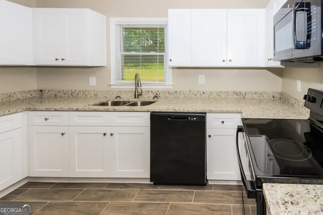 a kitchen with stainless steel appliances granite countertop a sink stove and cabinets