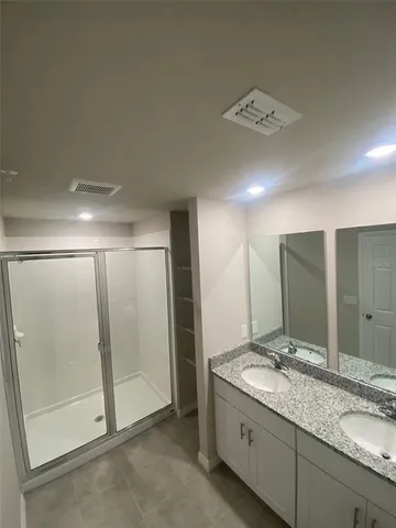 a bathroom with a double vanity sink and mirror