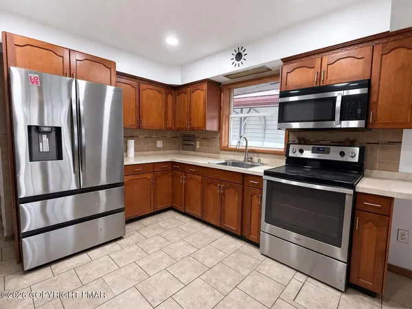 a kitchen with stainless steel appliances granite countertop a refrigerator stove top oven and sink