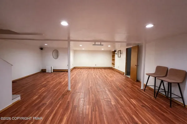 a view of a room with wooden floor and furniture