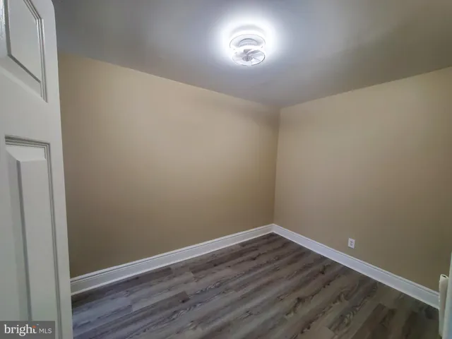 an empty room with wooden floor and entrance